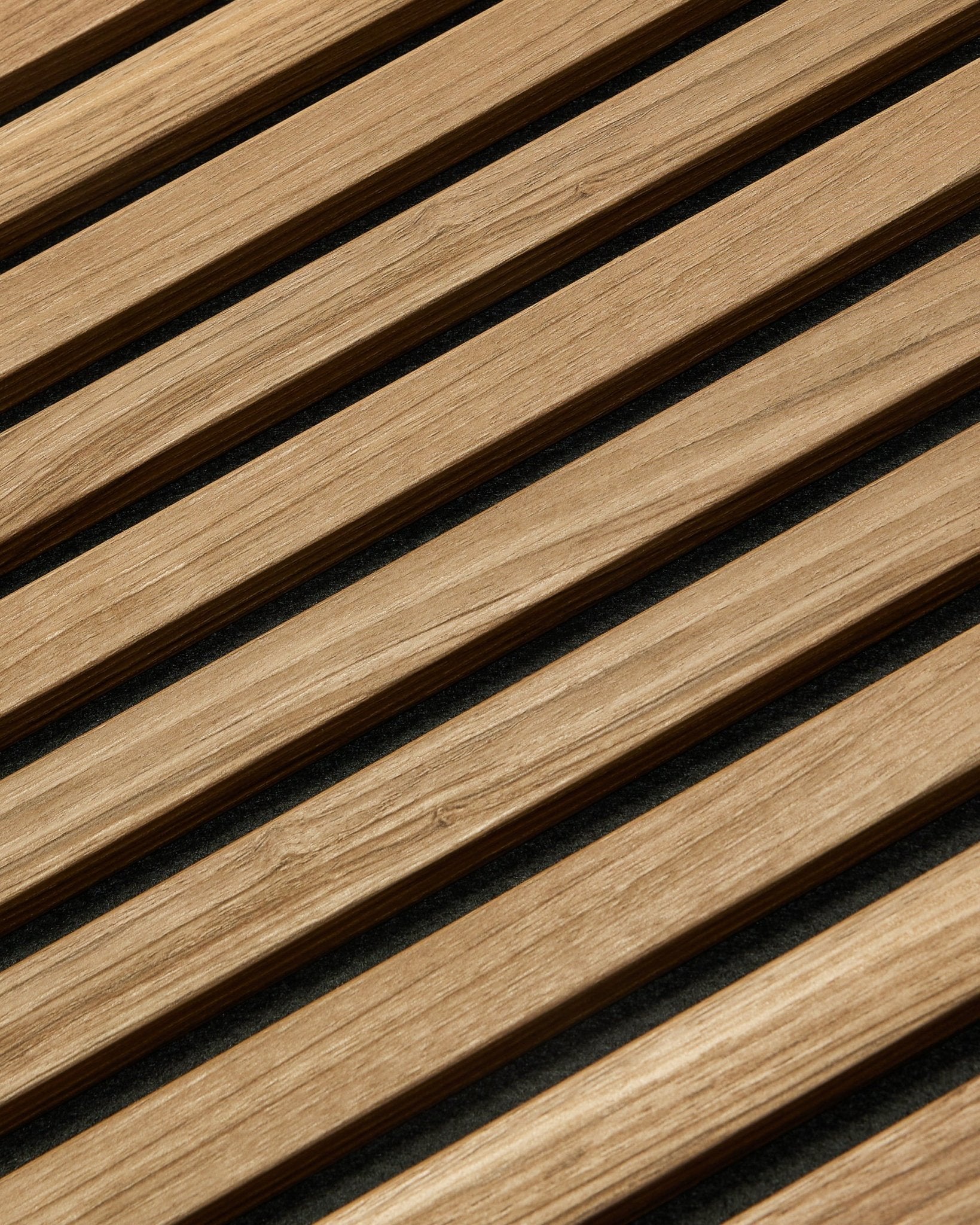 Primer plano en diagonal del WoodUpp Akupanel Essential Panel acústico en English Walnut, 240x60 cm, que muestra un acabado uniforme y un fondo oscuro entre cada lama de madera.